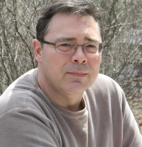 A headshot of a man wearing glasses.